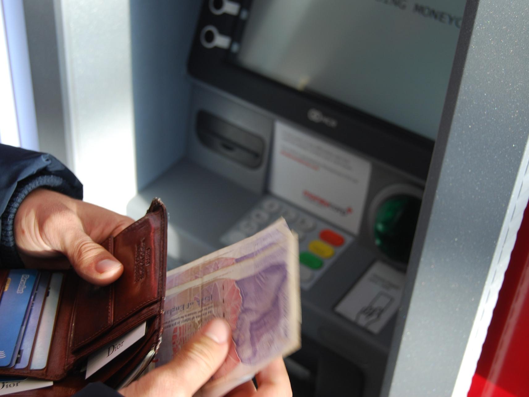 Gallery Image 04 person holding brown leather wallet and banknotes